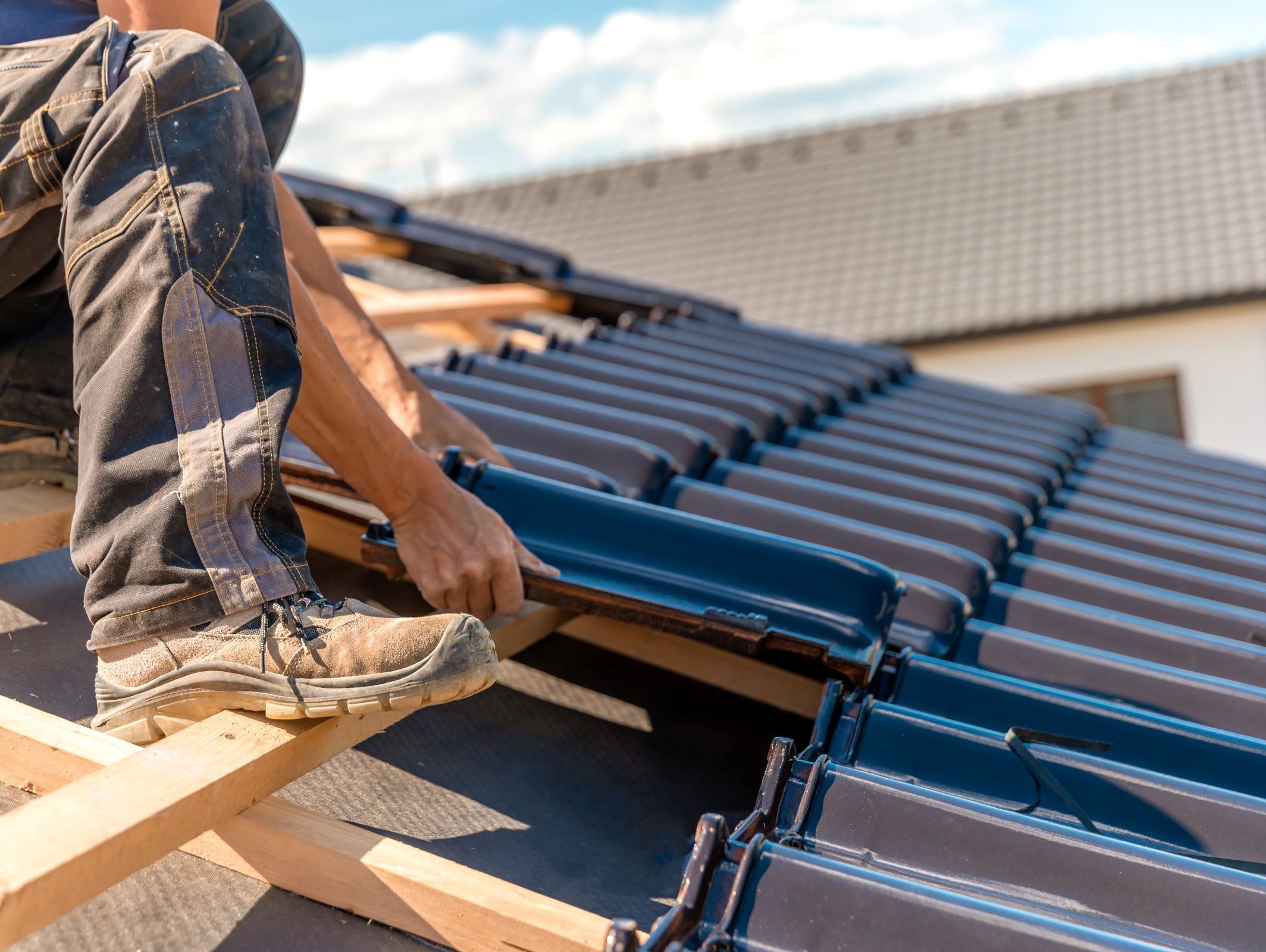Takläggare lägger nya takpannor på hus