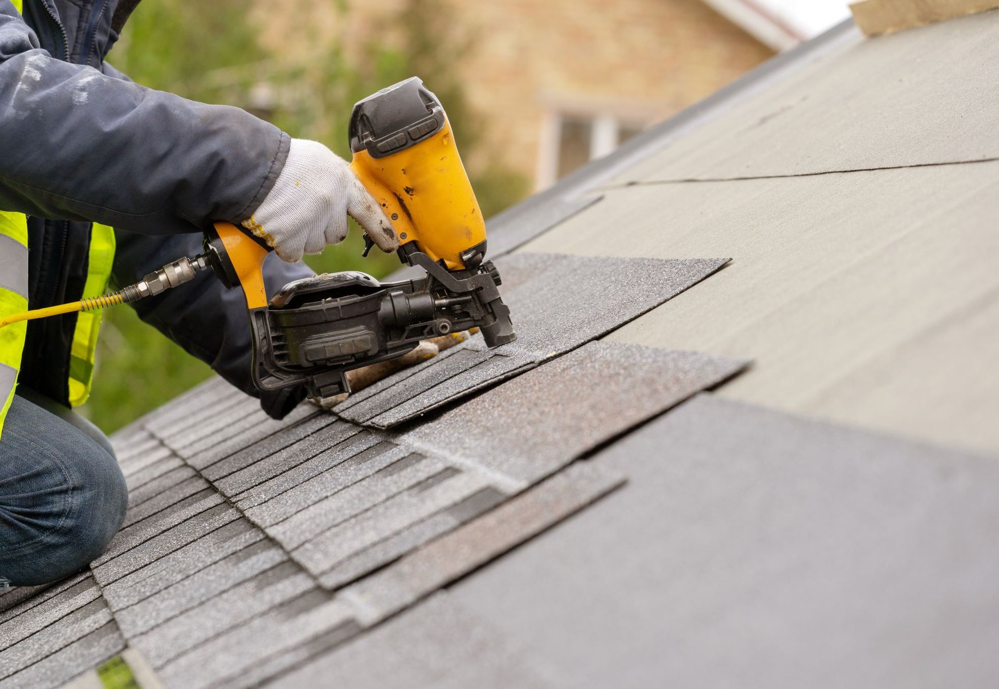 Hantverkare lägger takpannor med spikpistol